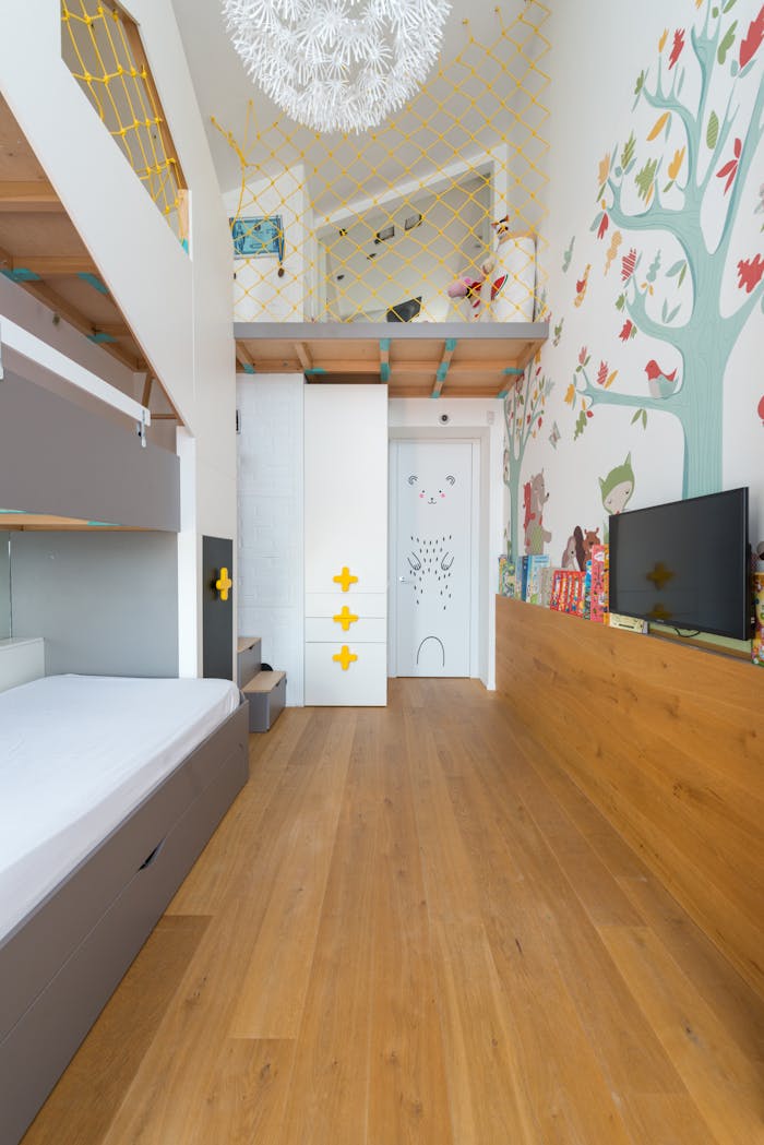 Charming kids' room featuring a loft bunk bed, playful decor, and colorful illustrations.